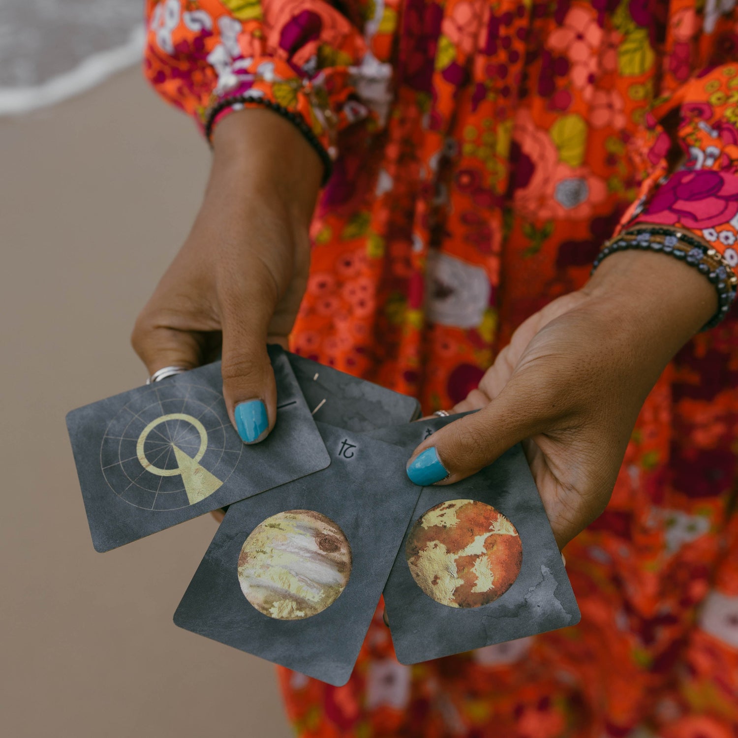 Astrology cards are displayed in the hand of an energy healer showcasing astrology reading services
