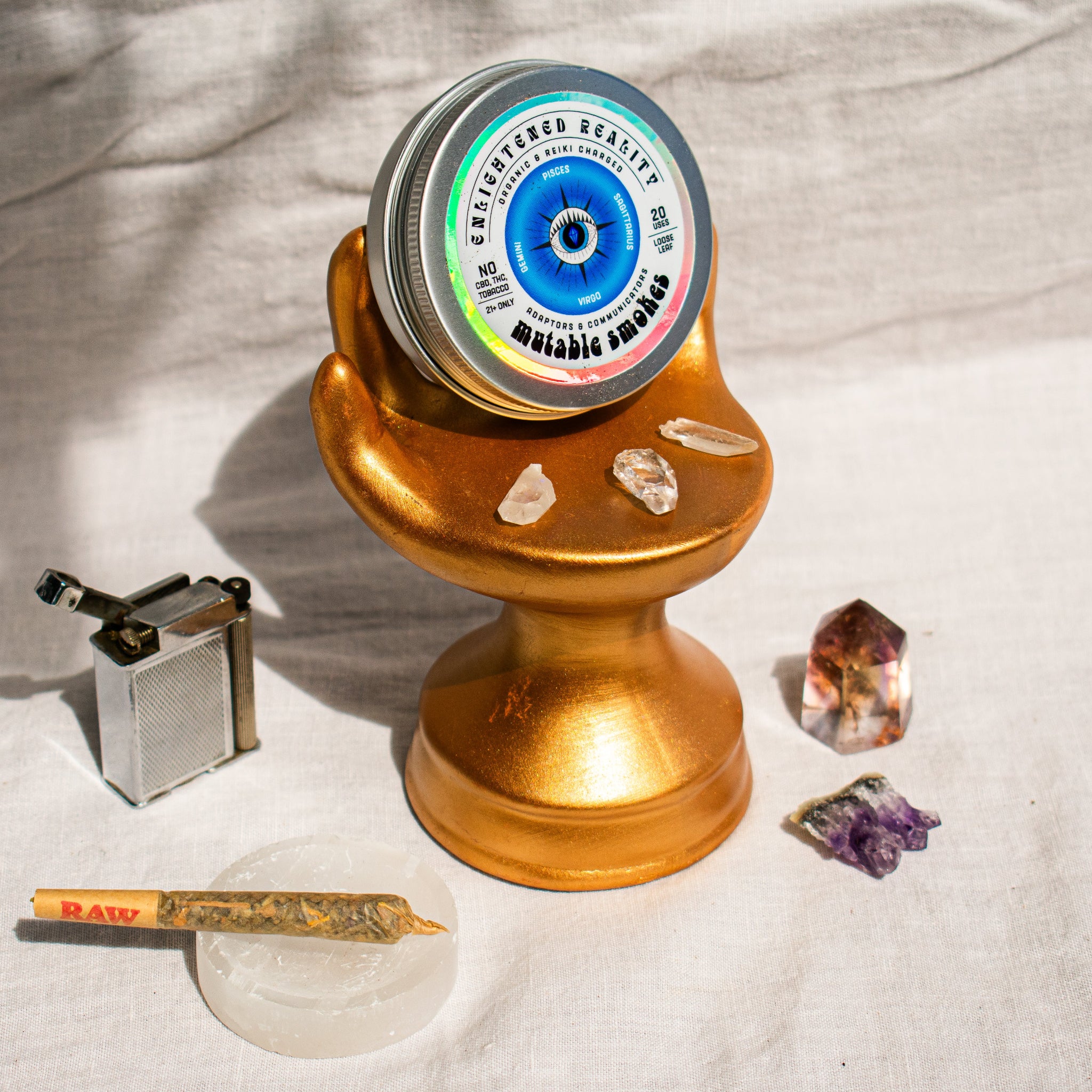 Organic Herbal Smoking Blend in metal tin on display stand surrounded by crystals for energetic balance and mindfulness