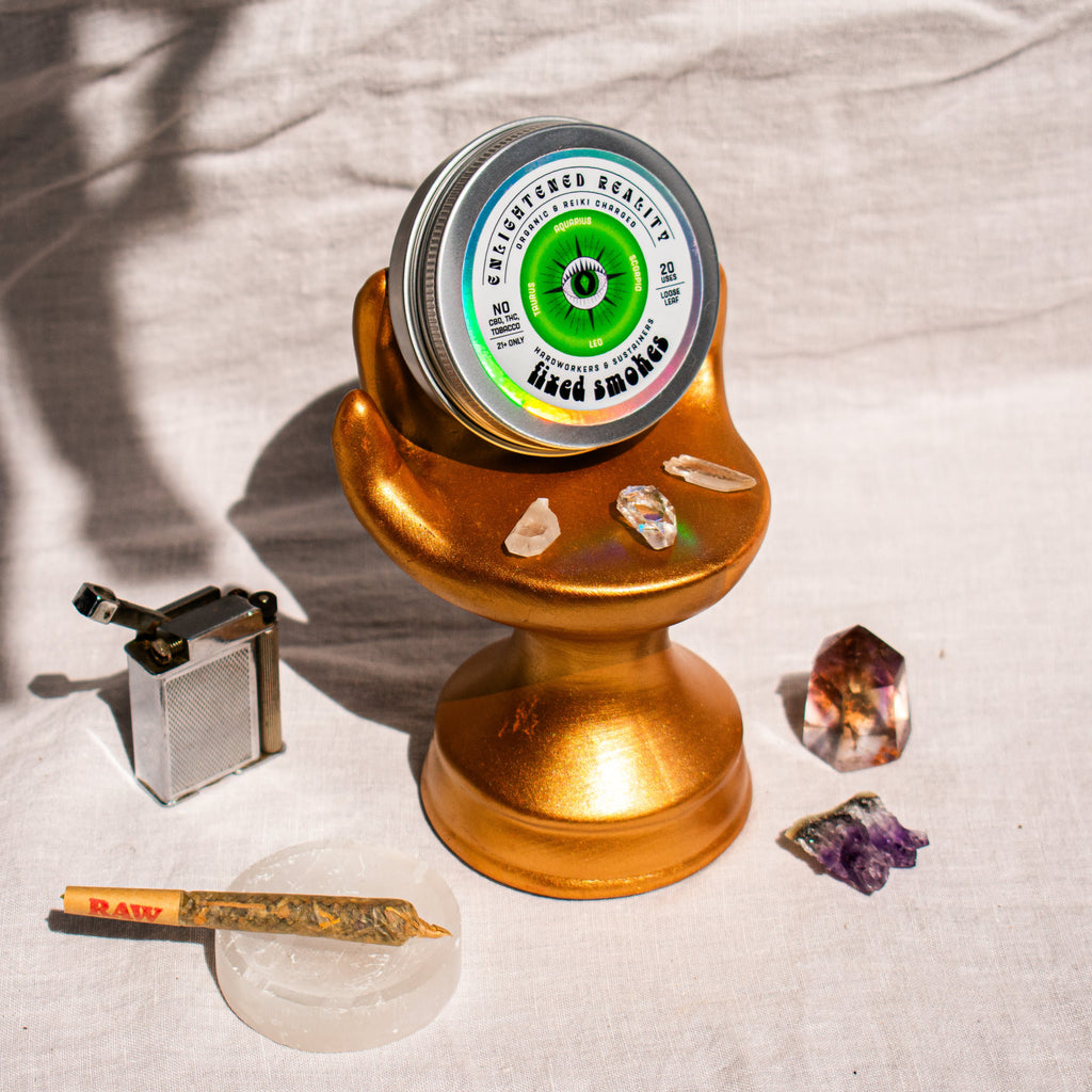 Organic Herbal Smoking Blend in metal tin on display stand surrounded by crystals for energetic balance and mindfulness