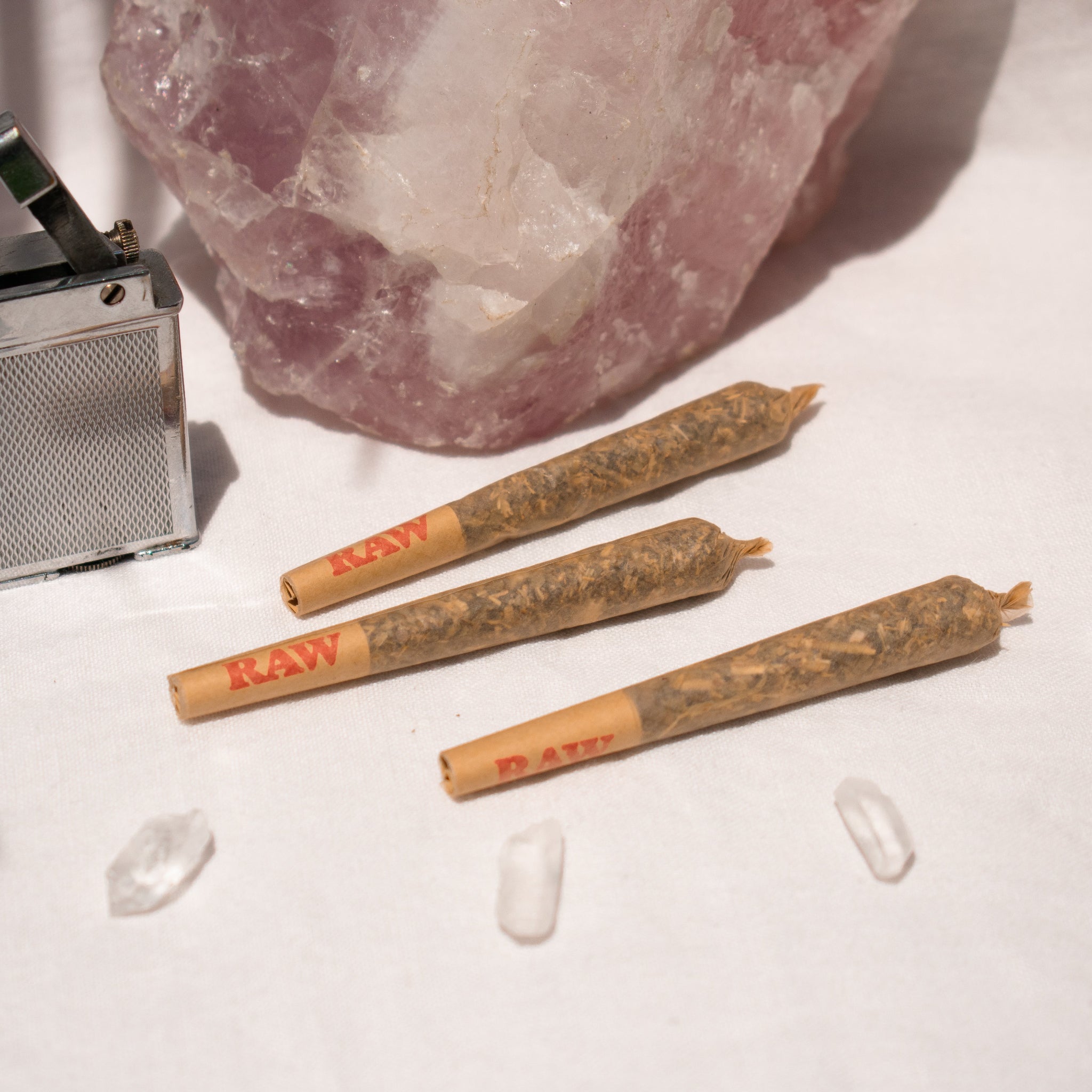 Trio of Organic single Pre Rolls Herbal Smoking Blends displayed with rose quartz for astrological and spiritual rituals