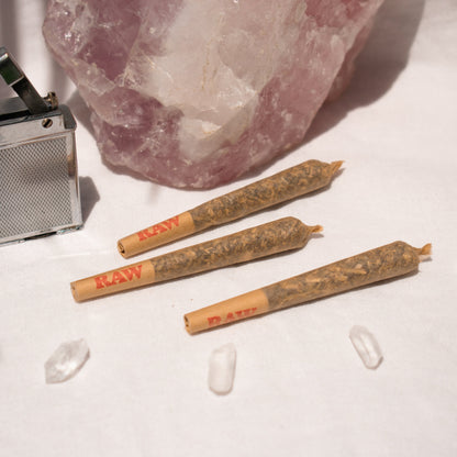 Trio of Organic single Pre Rolls Herbal Smoking Blends displayed with rose quartz for astrological and spiritual rituals